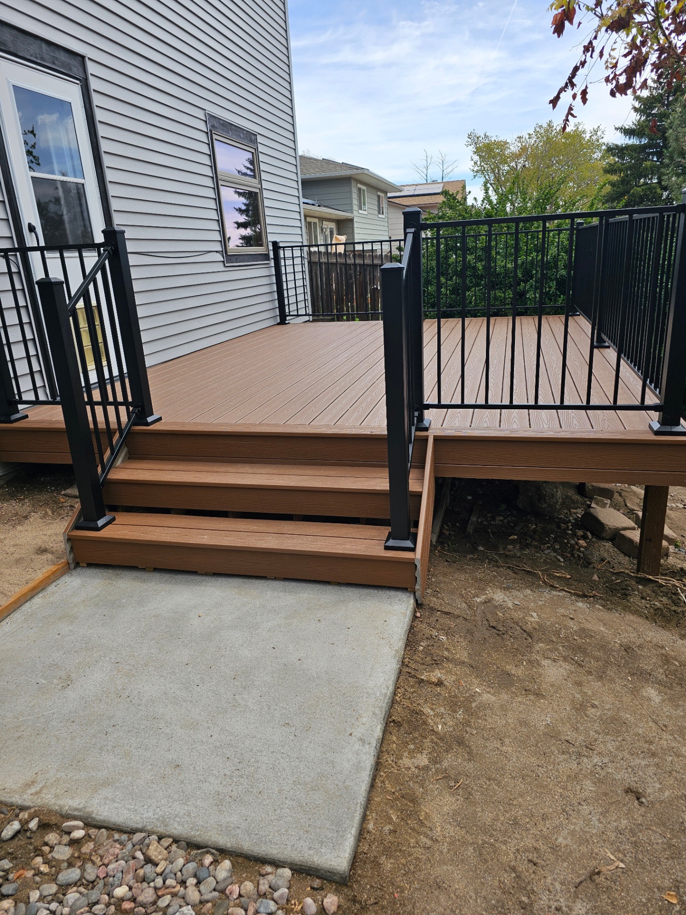 Custom brown composite deck with black metal railings and stairs built by All Custom Deck in Colorado Springs